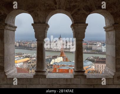 Bâtiment du Parlement hongrois vu à travers les arcades de bastion des pêcheurs sur la colline du château de Buda, Budapest avec Banque D'Images