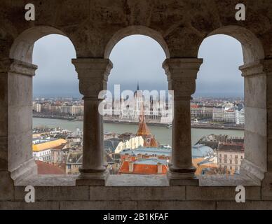 Bâtiment du Parlement hongrois vu à travers les arcades de bastion des pêcheurs sur la colline du château de Buda, Budapest avec Banque D'Images