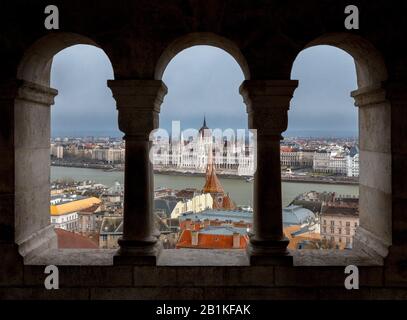 Bâtiment du Parlement hongrois vu à travers les arcades de bastion des pêcheurs sur la colline du château de Buda, Budapest avec Banque D'Images