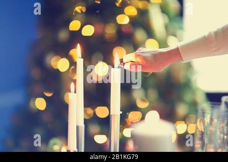 Femme imreconnaissable souriant et enflammant des bougies tout en créant une ambiance romantique en soirée à la maison Banque D'Images