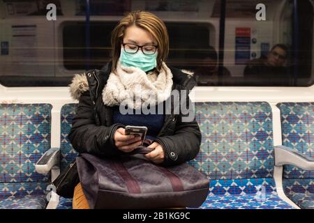 Une femme portant un visage sur le métro de Londres. Photo PA. Date De L'Image: Mercredi 26 Février 2020. Voir l'histoire de PA SANTÉ Coronavirus. Crédit photo devrait lire: Ian Hinchliffe/PA Fil Banque D'Images