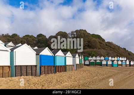 Plage huttes au Moyen-Chine avec promenade couverte de sable du mauvais temps récent à Bournemouth, Dorset UK sur une journée ensoleillée froide en février Banque D'Images