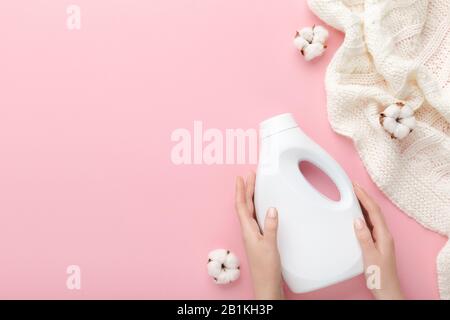 Mains féminines tenant une bouteille de produit de nettoyage en plastique blanc Banque D'Images