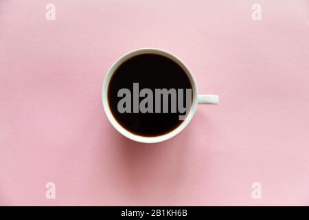 Une petite tasse de café sur fond rose Banque D'Images
