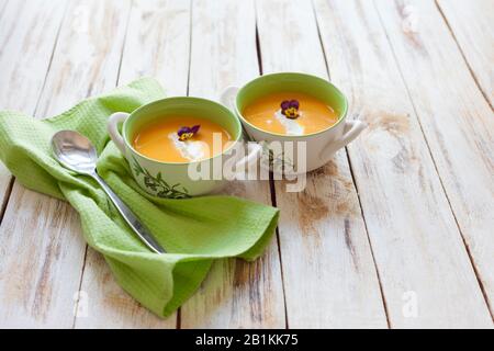 Soupe de purée, faite de citrouille orange, de patates douces et de carottes, servie avec de la crème aigre Banque D'Images