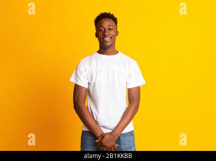 Un gars africain souriant et confiant sur fond jaune Banque D'Images