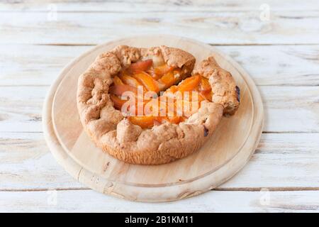 Galette avec abricot. Appelée aussi galette bretonne, galette des Rois, Galeta. Cuisine française. Sur fond blanc en bois ancien. Banque D'Images