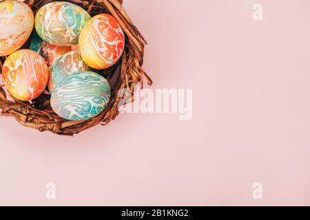 Des œufs de pâques dans le nid avec des tons roses pastel. Banque D'Images