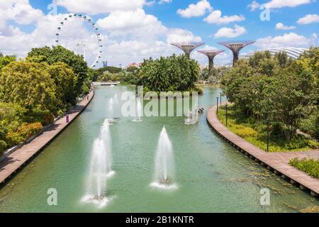 Fontaines d'eau dans le parc public, jardins sur la baie avec le Singapore Flyer et gratte-ciel sur les gratte-ciel, Singapour, Asie Banque D'Images