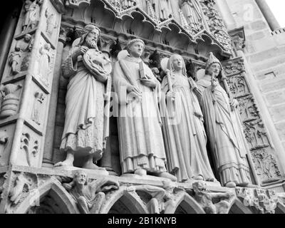 Sculptures de plusieurs Saints à l'entrée principale de la façade ouest de la cathédrale notre-Dame, photographiées en Monochrome à Paris, France Banque D'Images