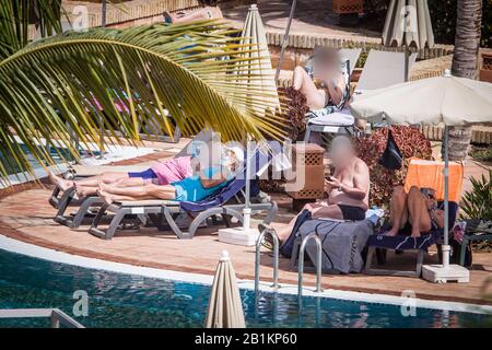 Teneriffa, Espagne. 26 février 2020. Les clients de l'hôtel peuvent bronzer près de la piscine. L'hôtel de Tenerife, qui a été mis en quarantaine à cause des cas de coronavirus, continue d'être mis en quarantaine par la police. Crédit: Arturo Rodríguez/dpa - à utiliser uniquement conformément à l'accord contractuel/dpa/Alay Live News Banque D'Images