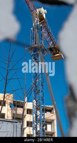 Chantier, grue et bâtiment incomplet sur le ciel bleu. Banque D'Images