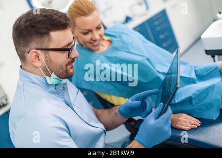 Dentiste examinant les dents d'un patient dans le bureau de dentiste.dentiste expliquant la radiographie au patient.Dents concept de santé.Personnes,stomatologie et santé c Banque D'Images