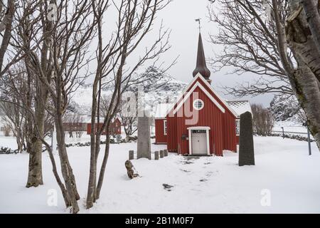 Une image hivernale de l'église de Flakstad peinte en rouge entourée de neige dans la campagne des îles Lofoten dans le comté de Nordland en Norvège l Banque D'Images
