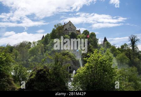 DAS Schloss liegt am linken Ufer des Rheins auf einem steilen Felsen über dem Rheinfall und bietet einen Ausblick über den Rhein und den Wasserfall. Banque D'Images