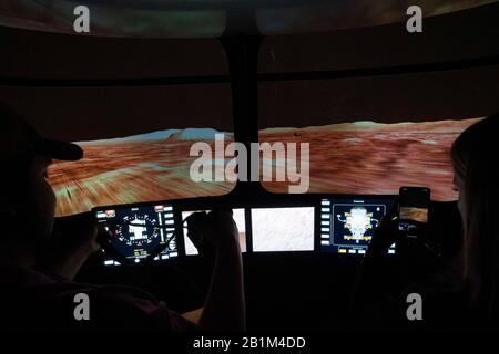 Les journalistes conduisent un futur simulateur Mars Rover à deux personnes dans le simulateur de génie des systèmes (ses) de la NASA à Houston. Banque D'Images