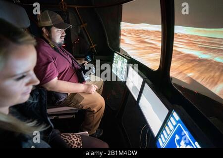 Les journalistes conduisent un futur simulateur Mars Rover à deux personnes dans le simulateur de génie des systèmes (ses) de la NASA à Houston. Banque D'Images