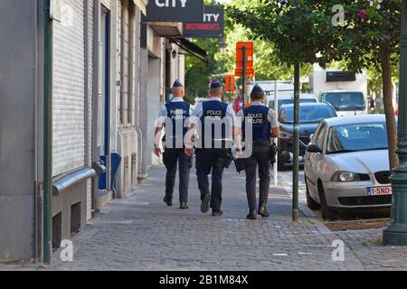 Bruxelles, Belgique - 03 juillet 2019: Trois policiers en gilet à protection contre les balles patrouillent dans la rue de la capitale. Banque D'Images