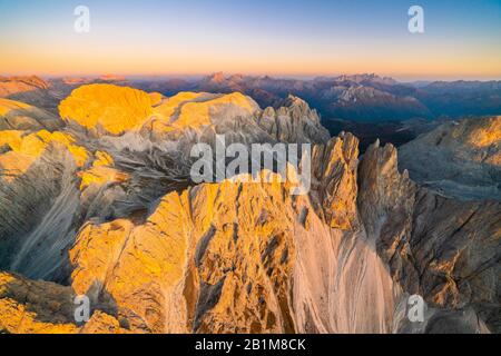 Coucher de soleil d'automne illuminé le majestueux groupe Torri Del Vajolet et Catinaccio, vue aérienne, Dolomites, Tyrol du Sud, Italie Banque D'Images