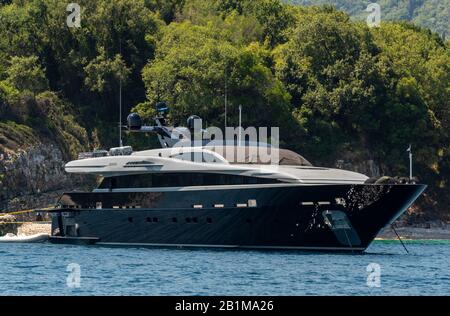 Un grand yacht ou un bateau à moteur de luxe amarré à l'ancre au large de l'île grecque de Corfou en Grèce. Banque D'Images