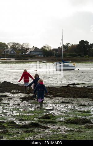 Jeunes enfants / enfants / enfants / enfants filles de 5, 7 et 9 ans marcher sur les vasières / marcher sur des vasières à marée basse quand la mer est sortie et il y a un danger de sable rapide près de Bosham Quay, Chichester dans le West Sussex. ROYAUME-UNI (114) Banque D'Images