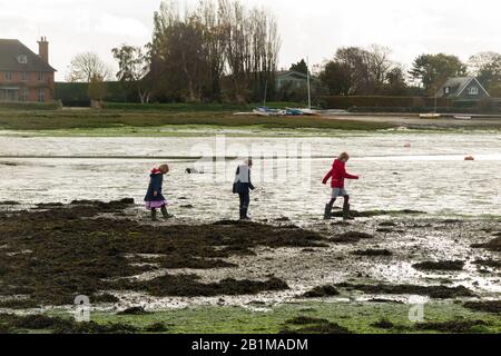 Jeunes enfants / enfants / enfants / enfants filles de 5, 7 et 9 ans marcher sur les vasières / marcher sur des vasières à marée basse quand la mer est sortie et il y a un danger de sable rapide près de Bosham Quay, Chichester dans le West Sussex. ROYAUME-UNI (114) Banque D'Images