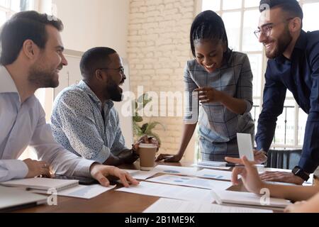 Les employés multiraciaux plaisantent et rient lors d'une réunion d'information dans la salle de conférence Banque D'Images