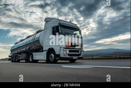 Camion-citerne de citerne de citerne près sur une route de l'autoroute avec un beau ciel spectaculaire coucher de soleil en arrière-plan Banque D'Images