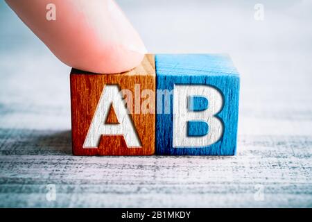 Choix A et B sur des blocs en bois sur UNE table, UN doigt touche le bloc A Banque D'Images