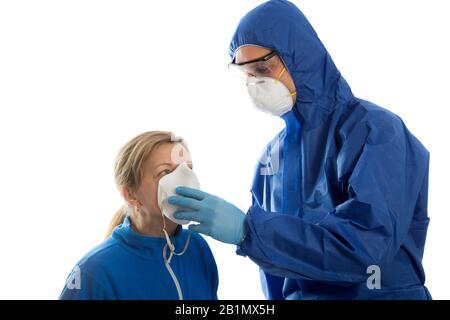L'homme dans les vêtements de protection donne le masque de visage aux femmes. Concept de coronavirus. Banque D'Images