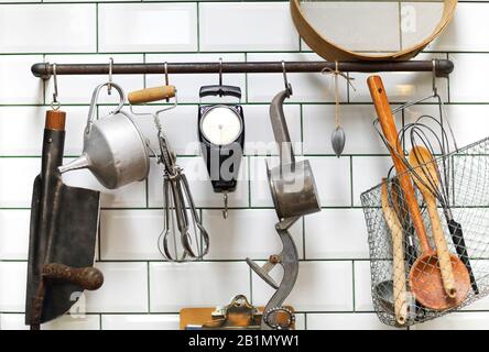 Divers ustensiles de cuisine vintage disposés sur le mur et les comptoirs près de l'évier dans une cuisine confortable à la maison Banque D'Images