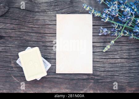 De plus feuille de papier blanc vide sur une table rustique en bois à côté du bouquet de fleurs sauvages bleues aromatiques Banque D'Images