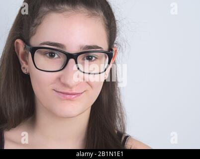 Portrait d'une fille de Brunette Teen à poil long espectacacled Smiling Banque D'Images