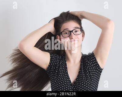 Portrait d'une fille Brunette Teen à poil long espectacacée dansante Banque D'Images