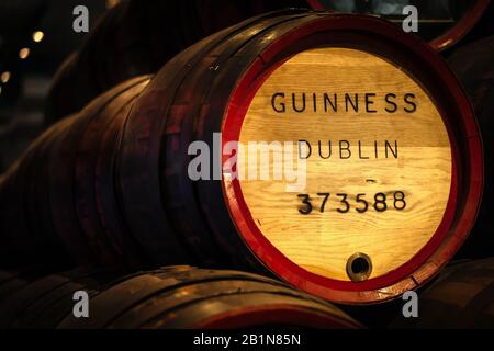 Dublin, Irlande, décembre 2017 les anciens fûts de Guinness en bois gris reposant dans des rangées dans la cave de la brasserie, fond flou. Guinness est une bière irlandaise emblématique Banque D'Images