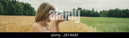 Image grand angle de la jeune femme photographe prenant des photos de beau paysage avec champ de blé doré. Banque D'Images