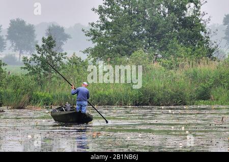 Un pêcheur dans son bateau, Pays-Bas, Overijssel, de Wieden Banque D'Images