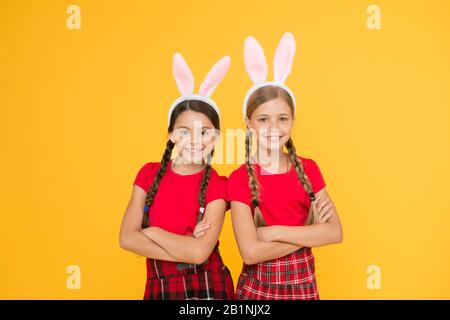 Équipe de Bunny. Concept de divertissement et d'événement. Vacances de printemps. Enfants dans les oreilles de lapin de lapin. Famille et Sisterhood. Uniforme scolaire pour petites écolières avec de longues oreilles de lapin. Jeux traditionnels de Pâques. Banque D'Images