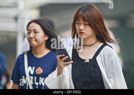 Wuhan: Une jeune fille utilisant son téléphone portable à la sortie de la station de métro Chuhe Hanije, rue Zhong Boi lu. Chine Banque D'Images