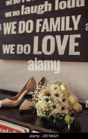 bouquet de daisies blanches de la mariée et élégantes chaussures beige sur le fond des inscriptions sur l'amour et la famille Banque D'Images