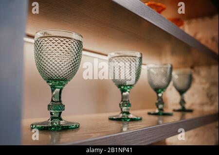 verre vert texturé identique pour les boissons se tiennent sur des étagères en bois dans le bar de la maison Banque D'Images