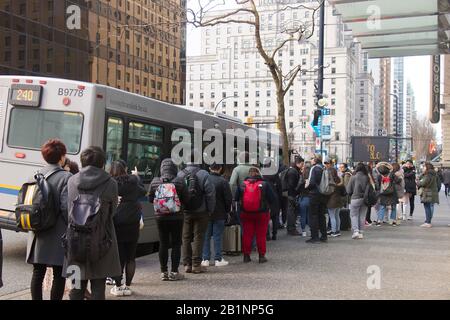 Vancouver, Canada - le 17 février 2020 : les gens s'y sont alignés pour monter à bord d'un autobus Translink sur la rue West Georgia dans le centre-ville de Vancouver Banque D'Images