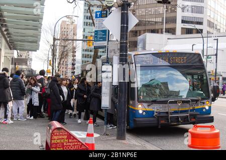 Vancouver, Canada - le 17 février 2020 : les gens s'y sont alignés pour monter à bord d'un autobus Translink sur la rue West Georgia dans le centre-ville de Vancouver Banque D'Images