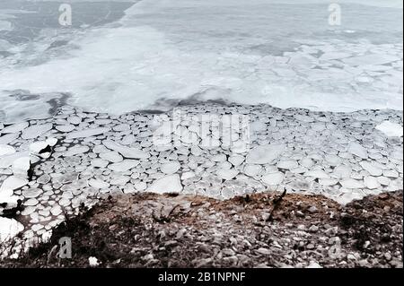 mer froide, recouverte de petites icules rondes inhabituelles, fonte de glace sur la mer, le bord tranchant de la glace est bordé par l'eau qui coule Banque D'Images