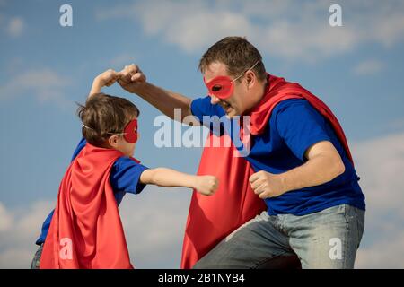 Père et fils jouer au super-héros de la journée. Les gens s'amuser à l'extérieur. Concept de famille accueillante. Banque D'Images