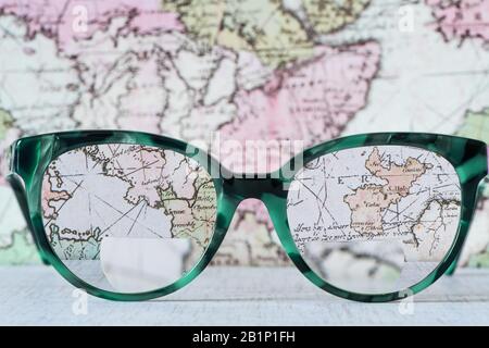 Lunettes lunettes lunettes lunettes avec bifocals et cadre bleu noir mode à crabotis style vintage sur Wood Desk avec fond de carte du monde. Banque D'Images