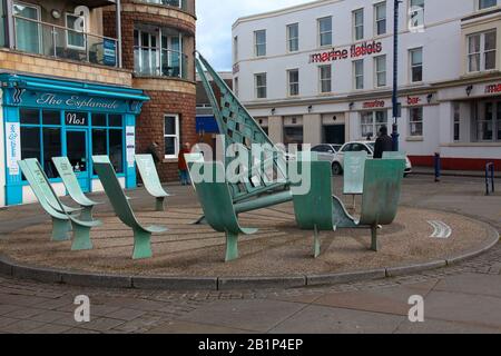Un ensemble de sièges avec une voile tous en bronze moulé situé à côté de la route principale à travers Porthcawl, juste sur le front de mer. Banque D'Images