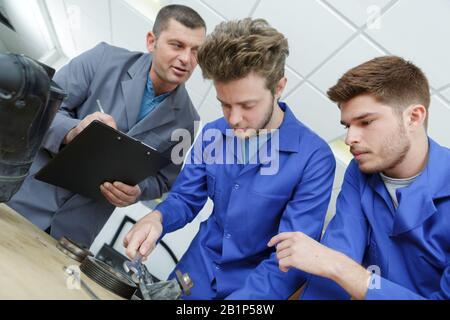 Formation des enseignants à aider les étudiants à être mécanique automobile Banque D'Images