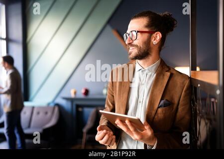 Portrait d'un jeune homme d'affaires heureux à l'aide d'une tablette numérique Banque D'Images