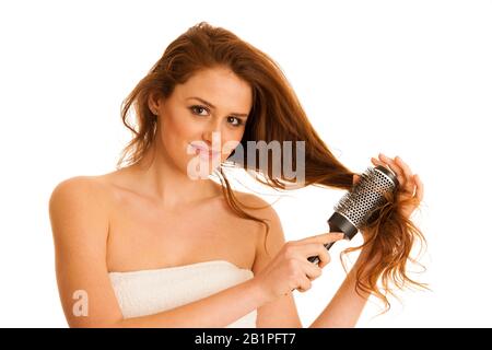 Belle jeune femme peignait ses cheveux avec une brosse isolée sur fond blanc Banque D'Images